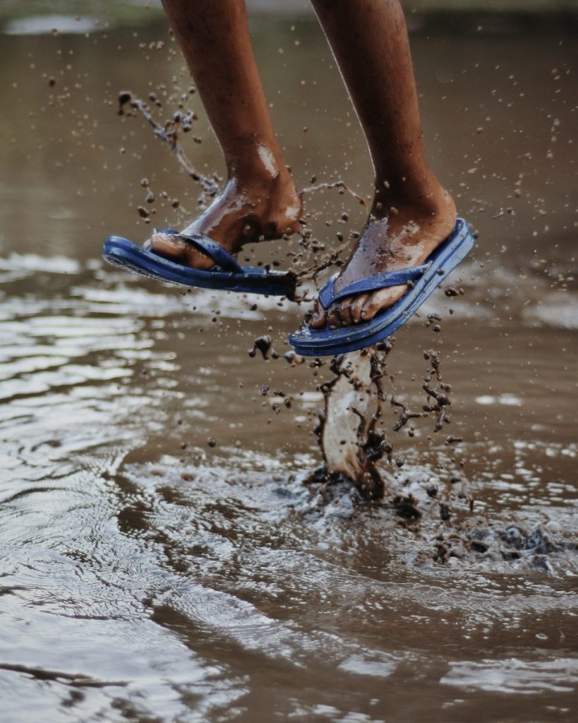 Child jumping in puddle