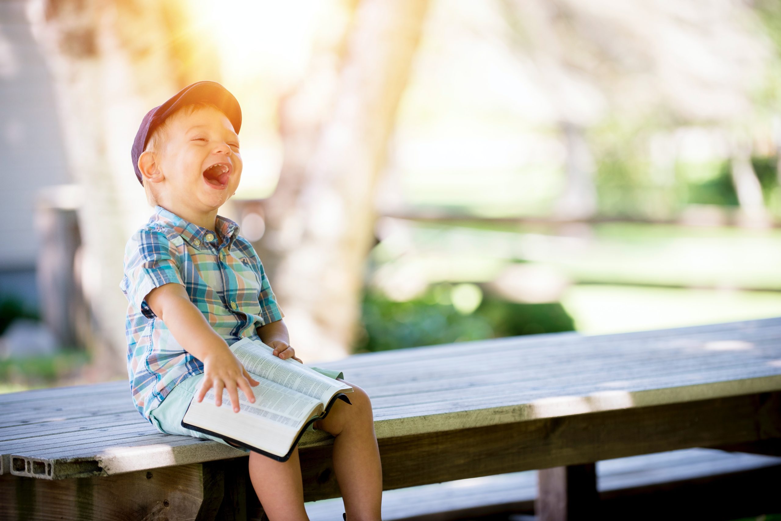 Child reading book, laughing