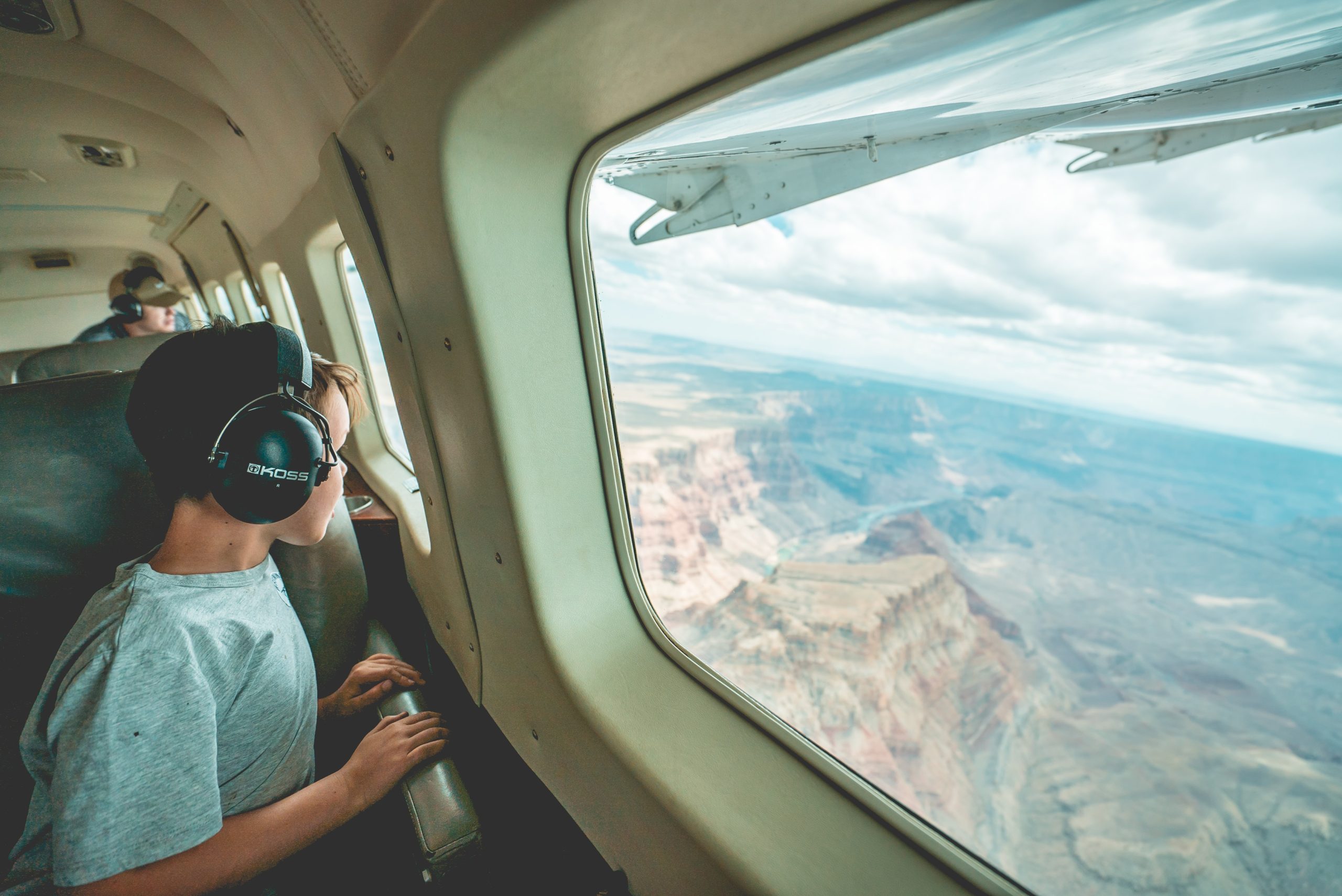 Boy with headphones on plane.